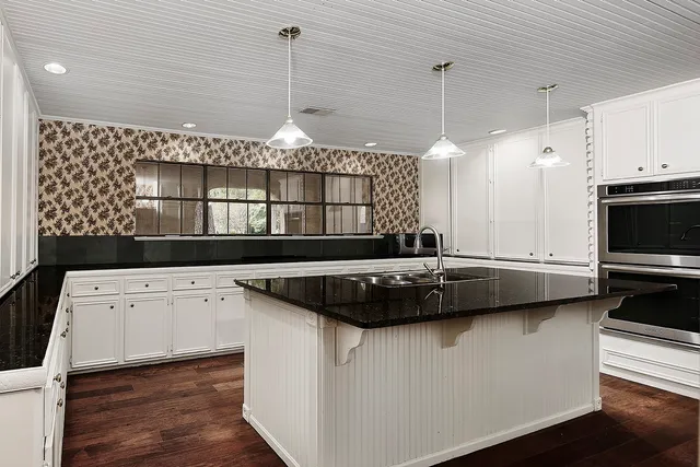 a kitchen with a sink a stove and cabinets