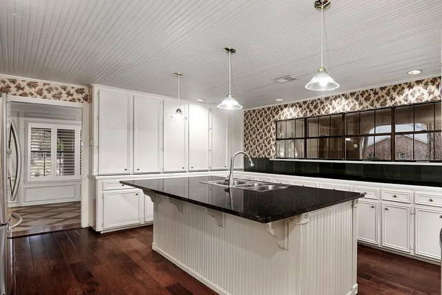 a kitchen with stainless steel appliances granite countertop a sink a stove and a wooden floors