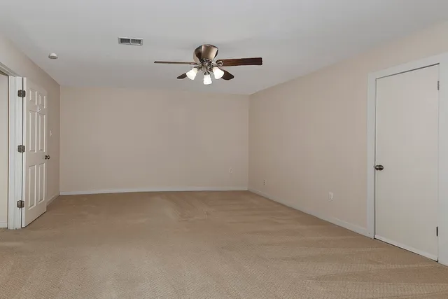 a view of room with a ceiling fan and a window