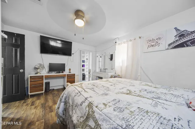 a spacious bedroom with a bed and a flat screen tv