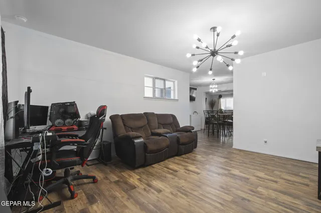 a living room with furniture a chandelier and a flat screen tv