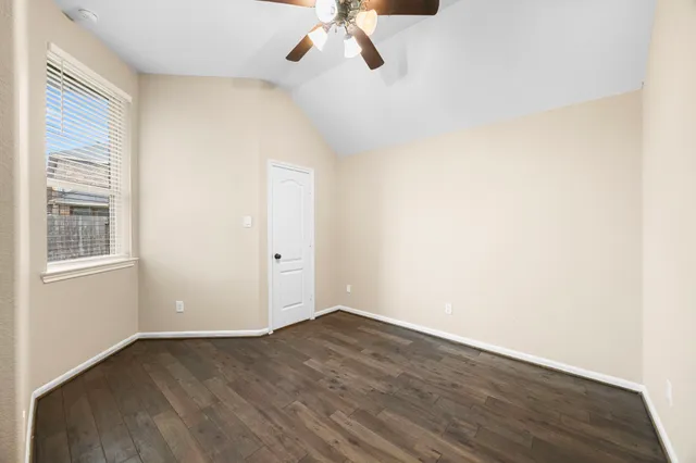 a view of a room with wooden floor and ceiling fan
