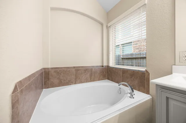 a bathroom with a bathtub and a window