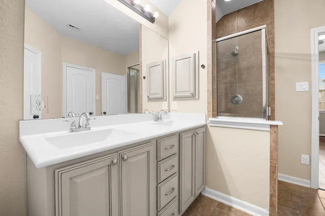 a bathroom with a sink a mirror a vanity and a shower