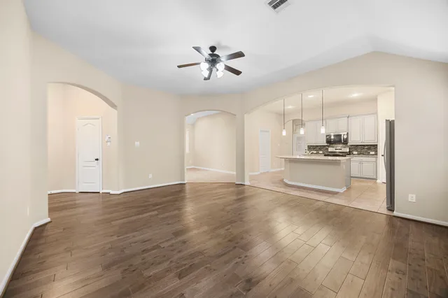 a view of a kitchen with a sink dishwasher a refrigerator and wooden floor