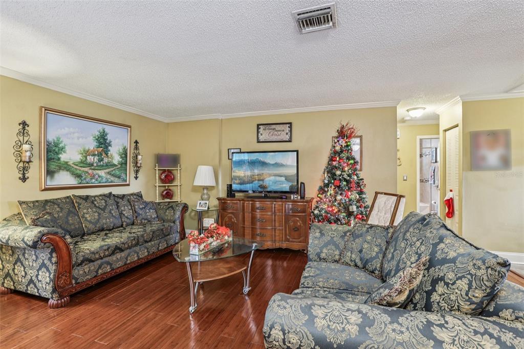 5575 58th Street North Kenneth City, FL 33709 - Photo 5 of 31 a living room with furniture and a flat screen tv