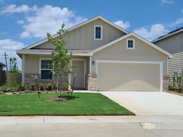 a front view of a house with a yard and trees