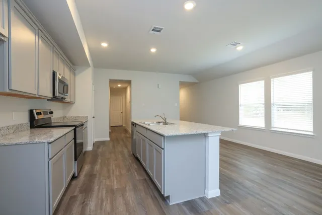 a kitchen with a sink stove top oven and cabinets