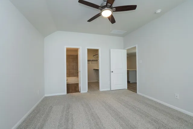 a bedroom with bed mirror and window