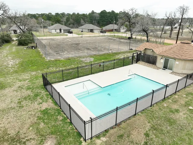 a view of a patio and yard with swimming pool