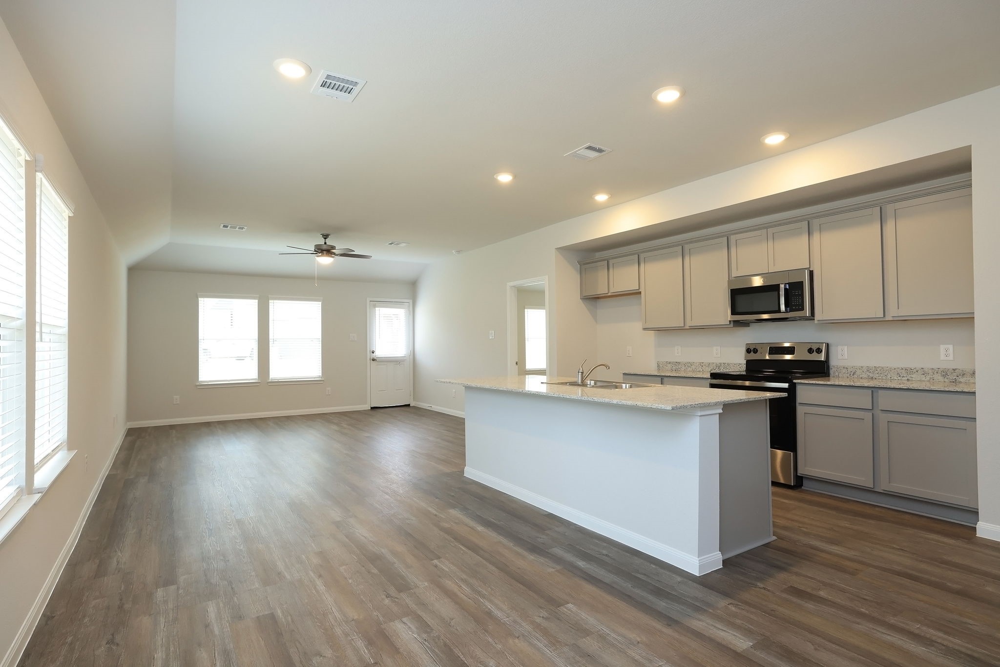 26439 Lake Shore Drive Hempstead, TX 77445 - Photo 6 of 45 a kitchen with stainless steel appliances granite countertop a stove top oven a sink dishwasher a refrigerator and white cabinets with wooden floor