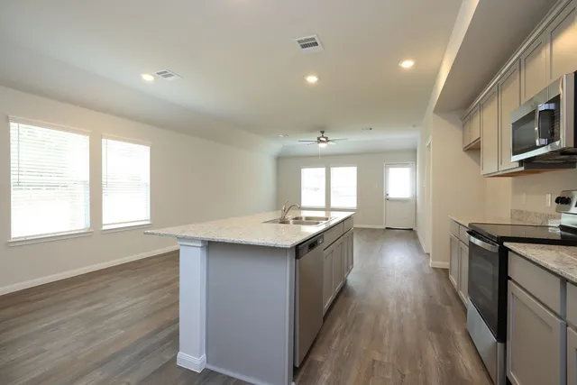 a kitchen with stainless steel appliances granite countertop a sink stove and wooden floor