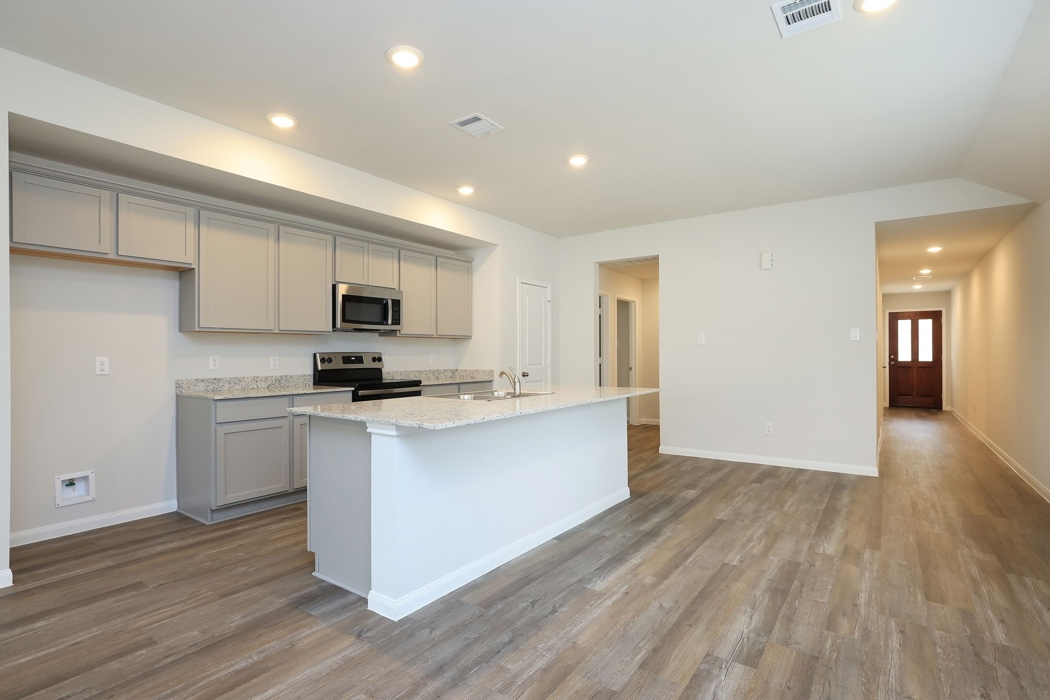 26439 Lake Shore Drive Hempstead, TX 77445 - Photo 8 of 45 a kitchen with stainless steel appliances granite countertop a stove top oven a sink dishwasher and a refrigerator with wooden floor