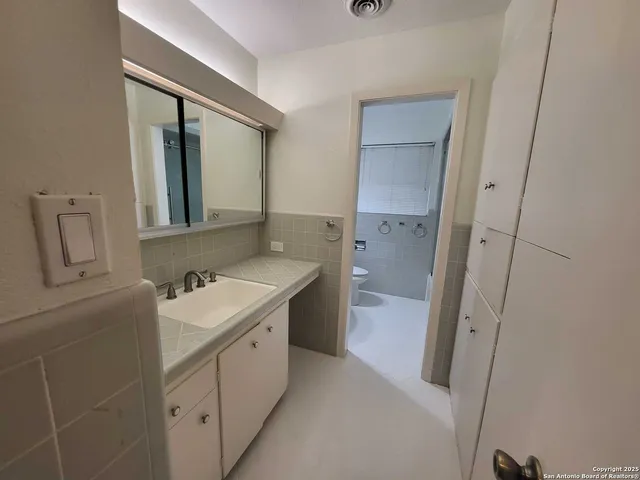 a bathroom with double vanity sink and mirror