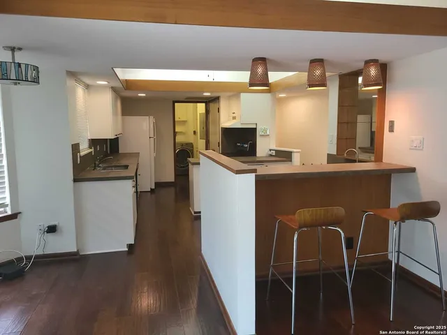 a kitchen with stainless steel appliances granite countertop a table chairs and a refrigerator