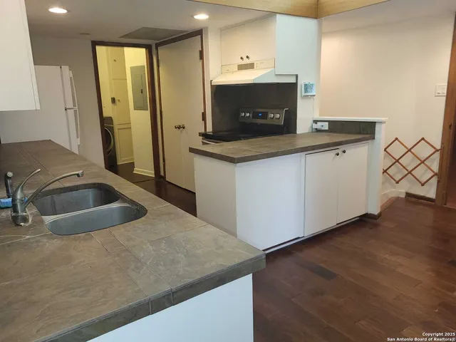 a kitchen with stainless steel appliances granite countertop a sink and a stove
