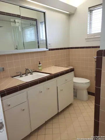 a bathroom with a double vanity sink and a toilet
