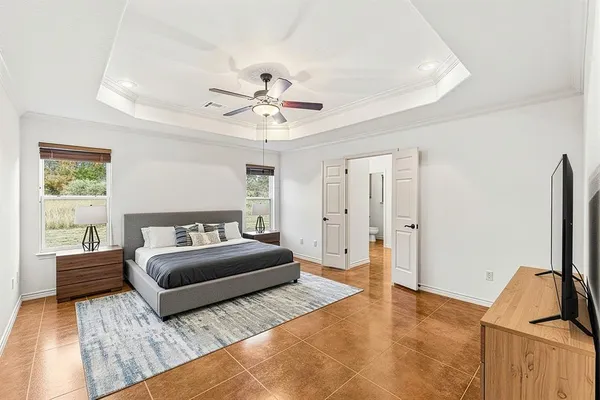 a bedroom with a large bed and a flat screen tv