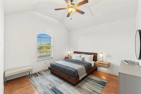 a bedroom with a bed wooden floor and window