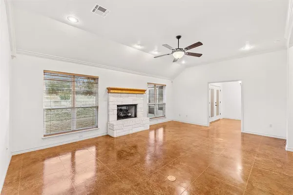 a view of an empty room with a fireplace and a window