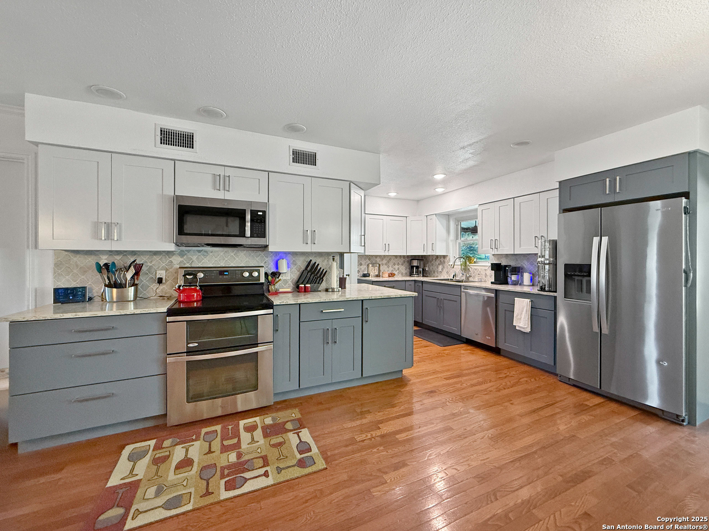 1406 Harper Road Kerrville, TX 78028 - Photo 12 of 33 a kitchen with granite countertop a refrigerator and a stove top oven