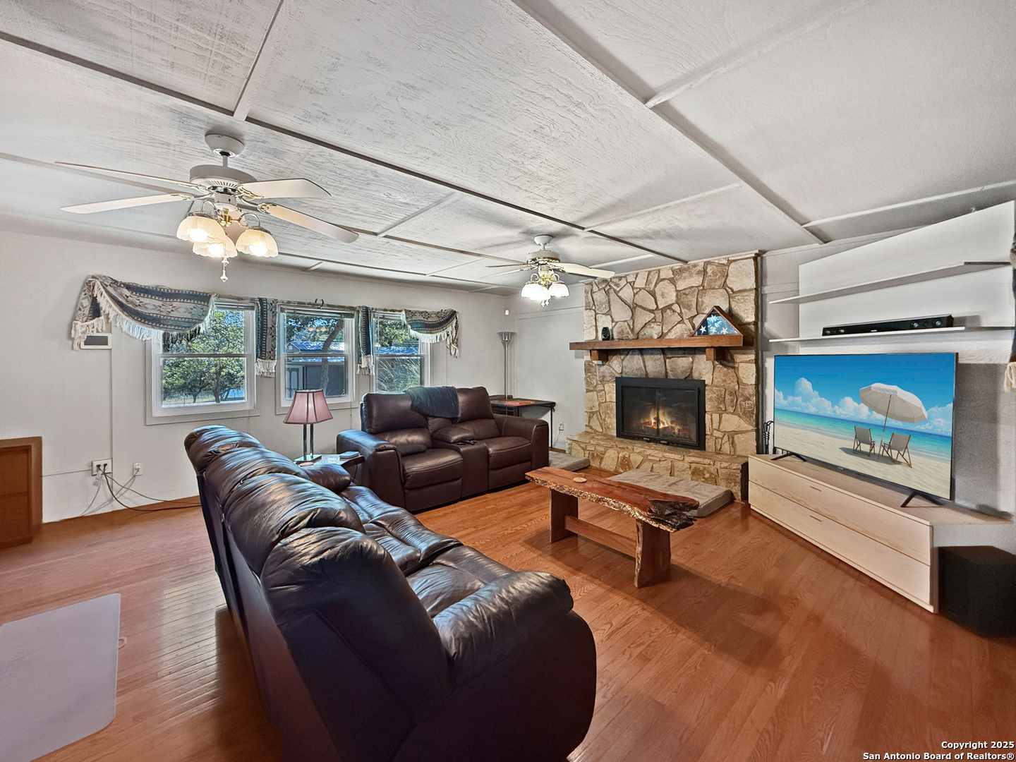 1406 Harper Road Kerrville, TX 78028 - Photo 17 of 33 a living room with furniture a fireplace and a flat screen tv
