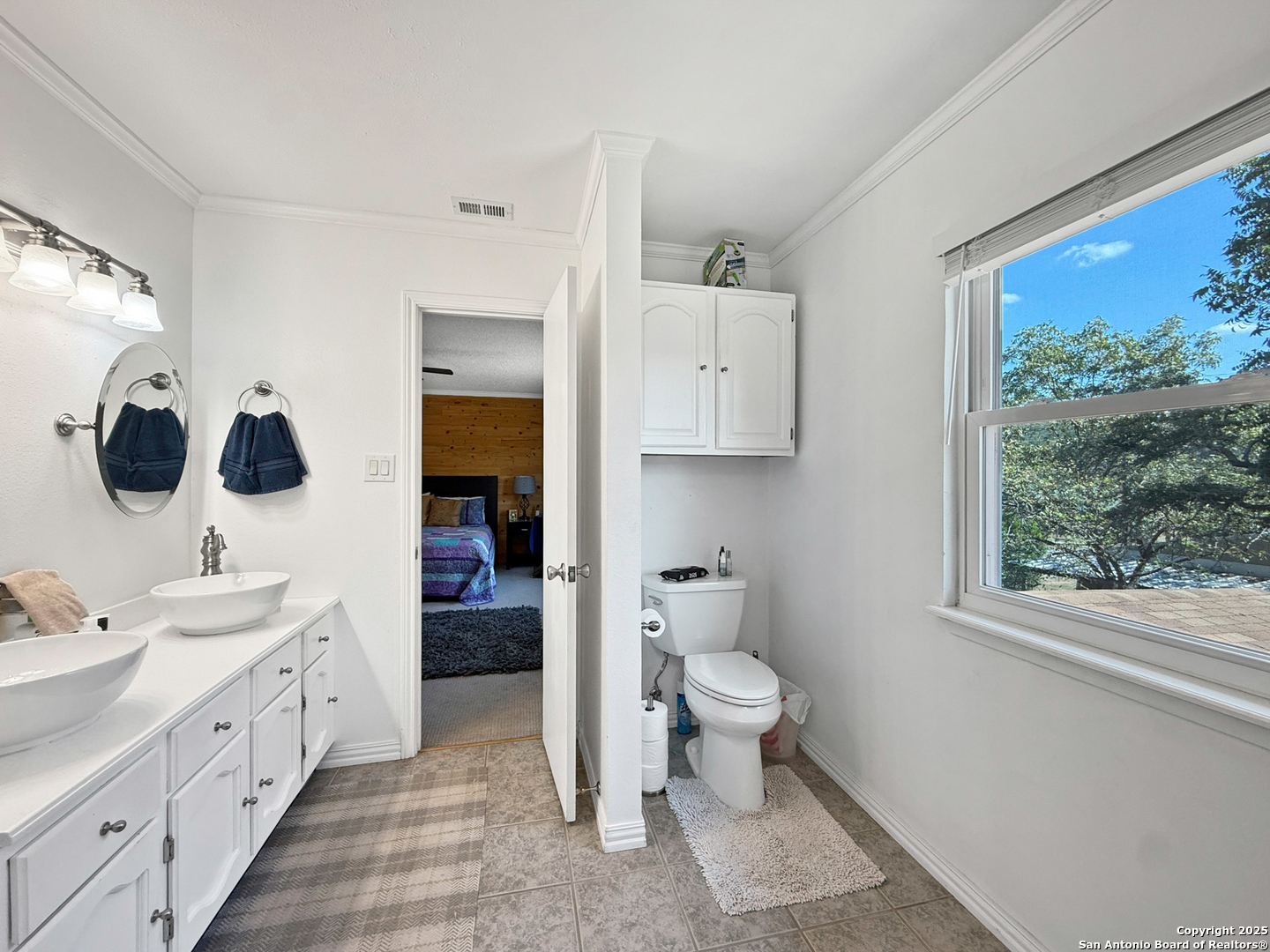 1406 Harper Road Kerrville, TX 78028 - Photo 20 of 33 a spacious bathroom with a toilet sink double vanity and mirror