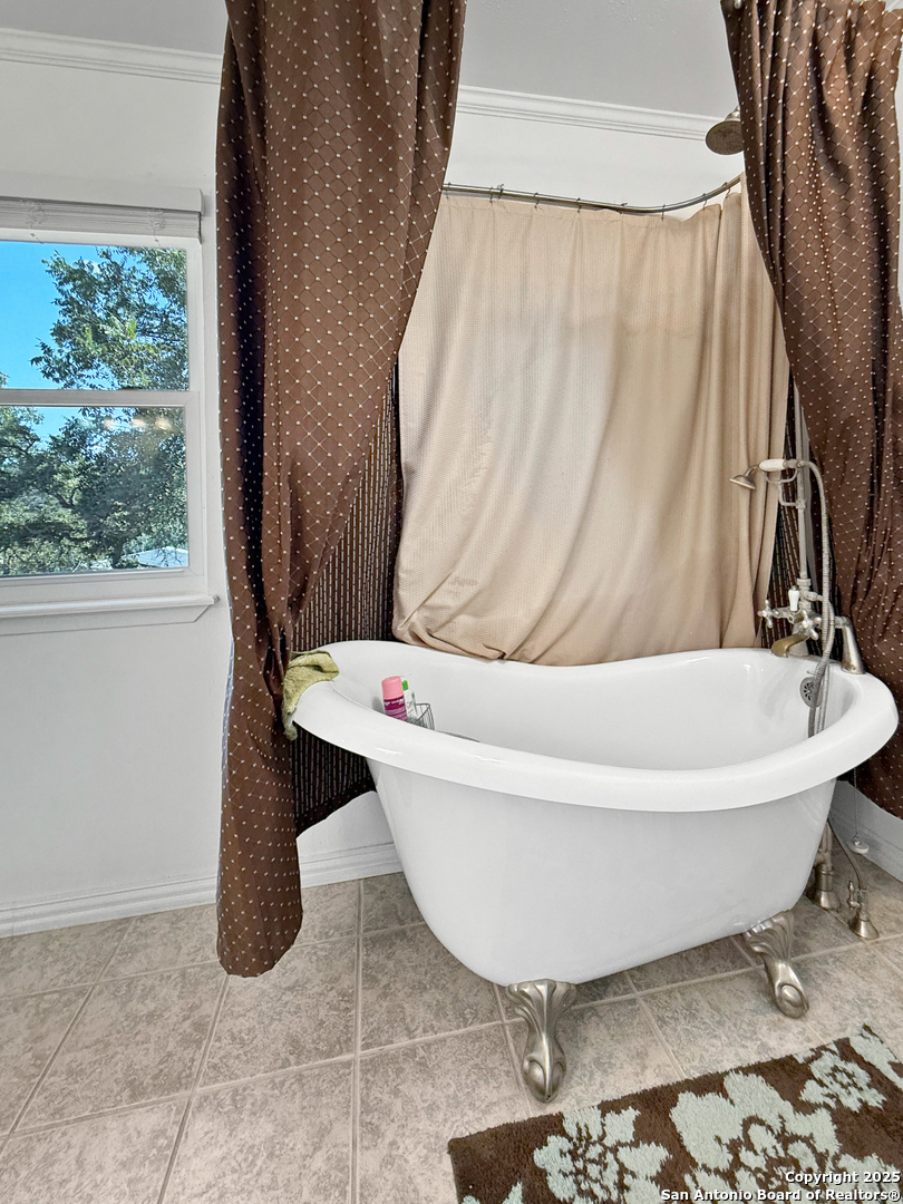 1406 Harper Road Kerrville, TX 78028 - Photo 21 of 33 a white bath tub sitting in a bathroom next to a window