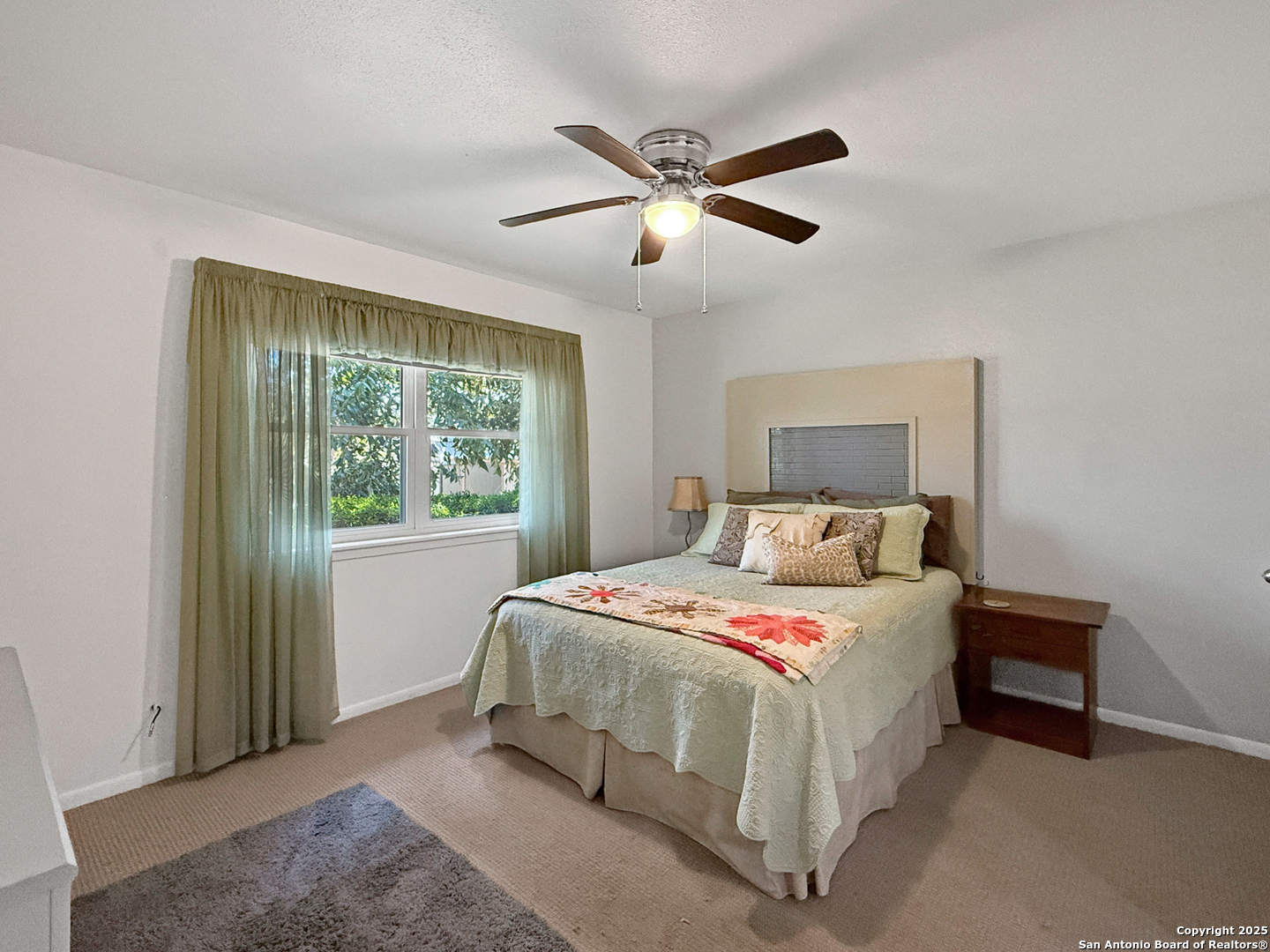 1406 Harper Road Kerrville, TX 78028 - Photo 22 of 33 a bedroom with a large bed and a chandelier