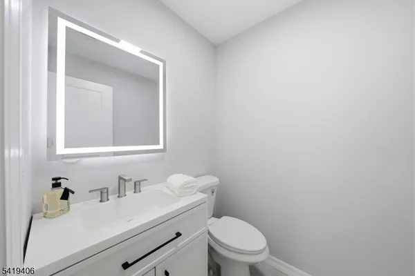a bathroom with a sink vanity mirror and toilet