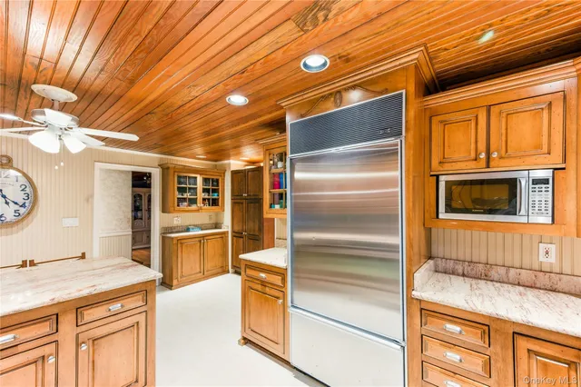 a kitchen with a stove a refrigerator a dining table and chairs with wooden floor