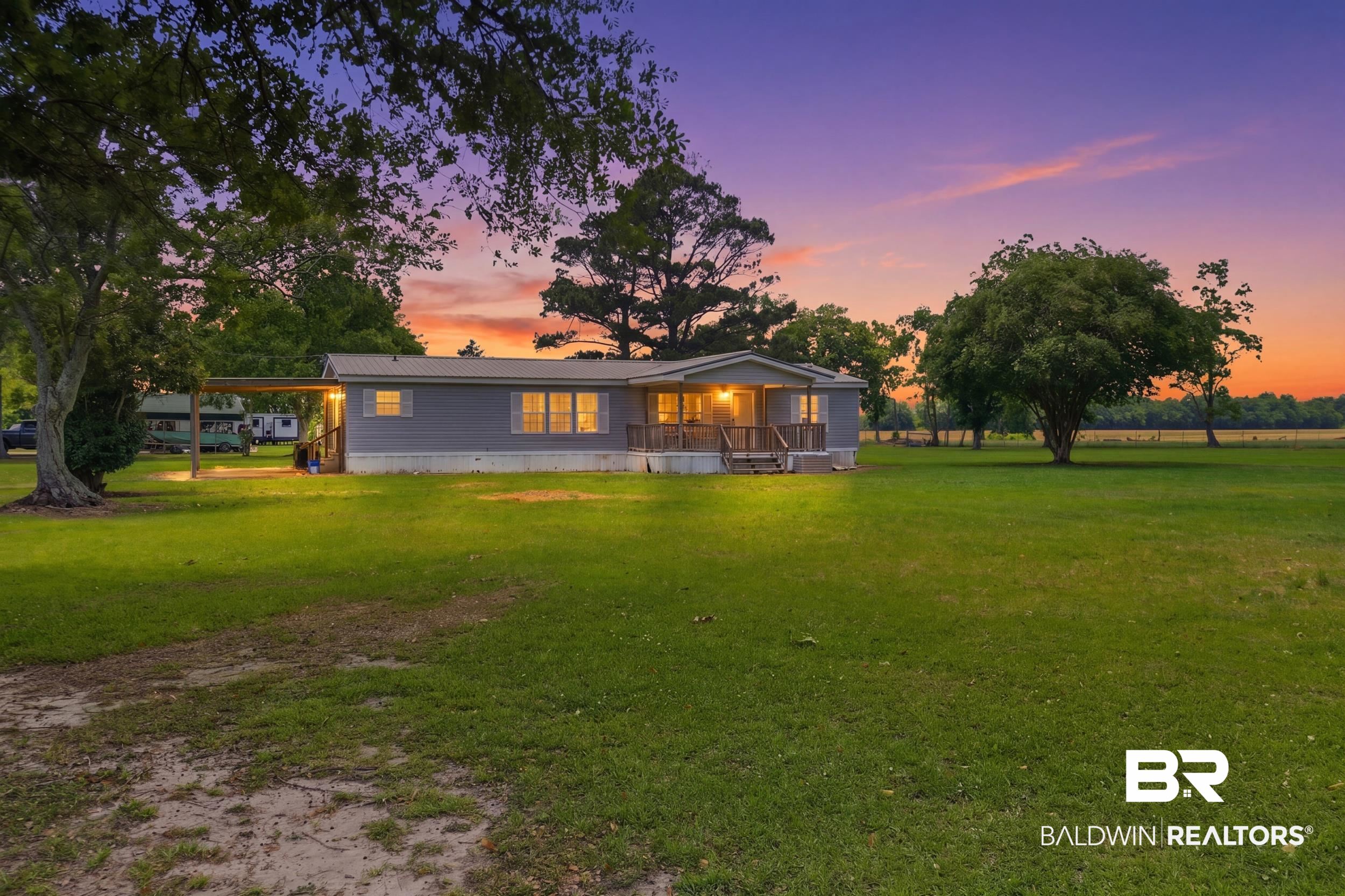 926 Tumbling Lane Atmore, AL 36502 - Photo 1 of 56 Single-story residence featuring a gray exterior with a metal roof and a covered carport