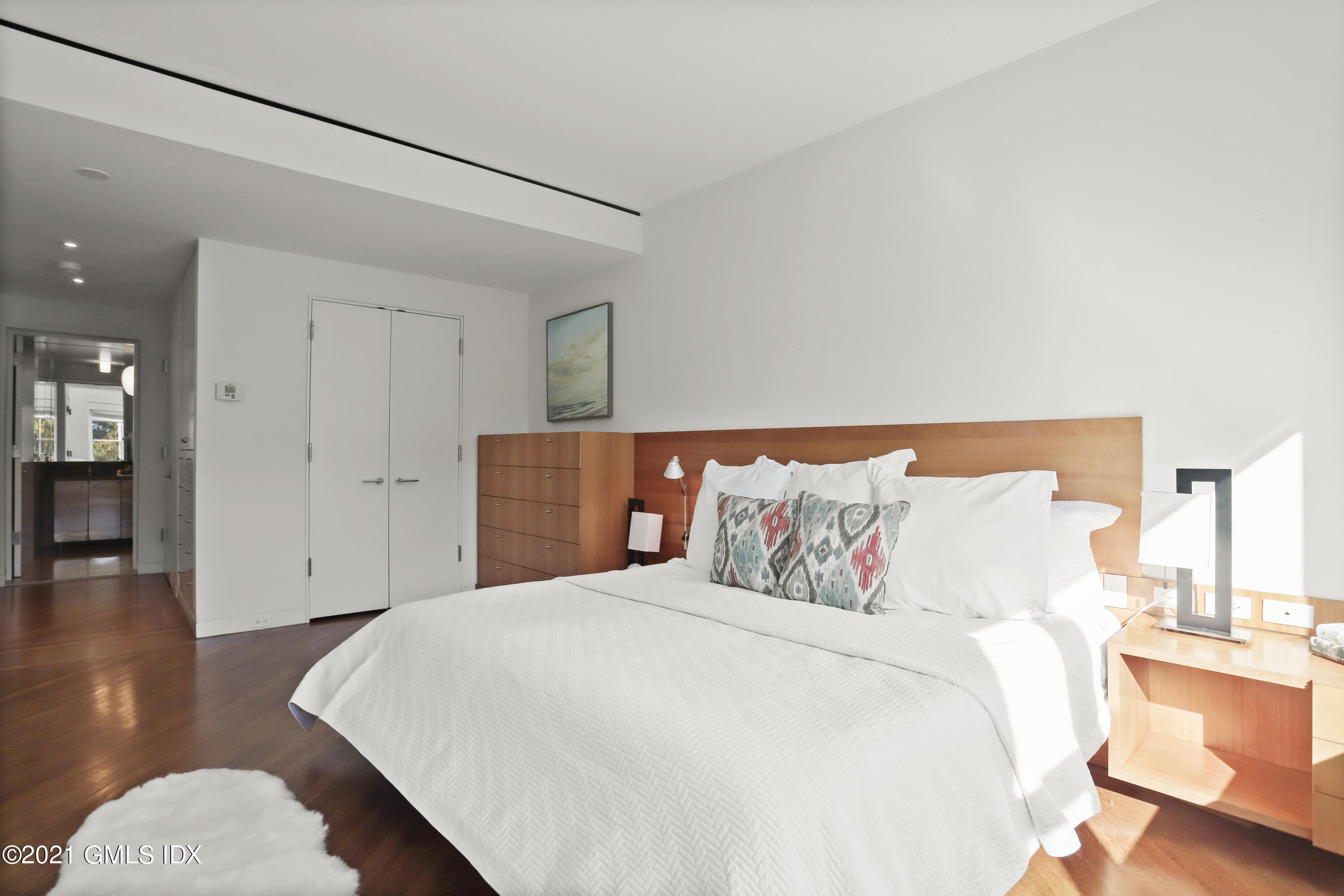 636 Steamboat Road, Unit 4A SOUTH Greenwich, CT 06830 - Photo 21 of 30 a bedroom with a large bed and wooden floor