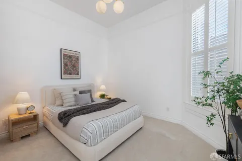 a bedroom with a bed lamp and a potted plant