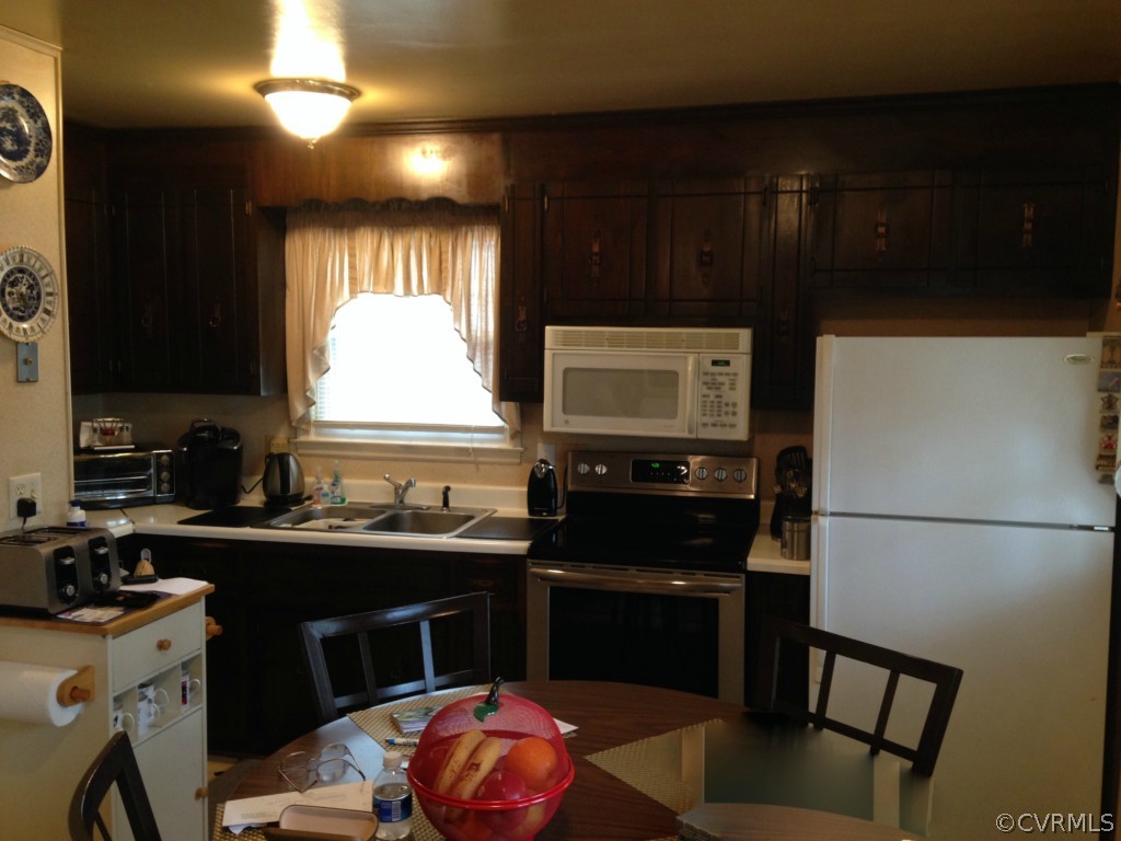 16131 Sandwave Road Chester, VA 23831 - Photo 5 of 24 a kitchen with a sink a stove a microwave and cabinets