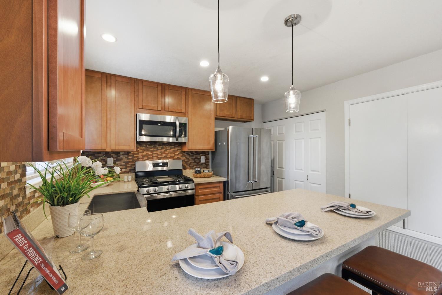 74 Hector Lane Novato, CA 94949 - Photo 16 of 32 a kitchen with stainless steel appliances granite countertop a sink a stove a dining table and chairs with wooden floor