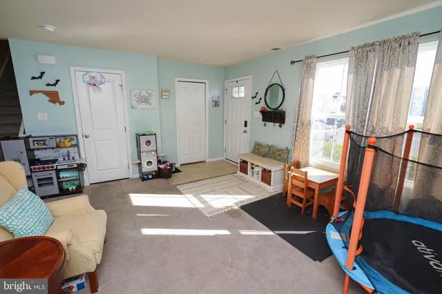 a living room with furniture a rug and a window