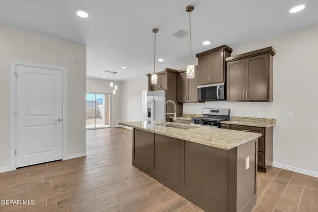 a kitchen with a sink a counter space appliances and cabinets