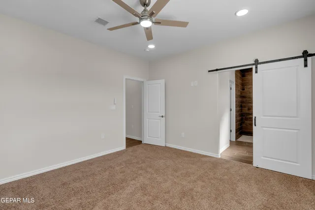 an empty room with closet and a ceiling fan