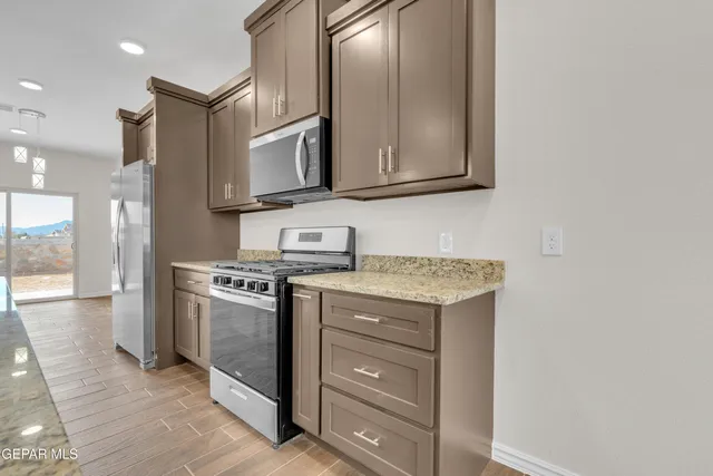 a kitchen with stainless steel appliances granite countertop a stove and a microwave
