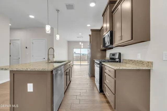 a kitchen with granite countertop a sink and a stove