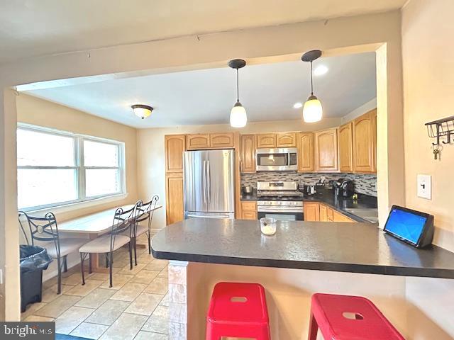 12405 Sweet Briar Road Philadelphia, PA 19154 - Photo 4 of 28 a kitchen with a stove a counter space dining table and chairs