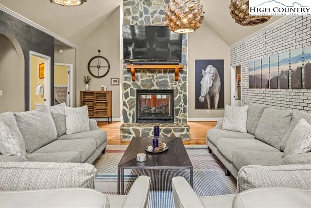 a living room with fireplace furniture and a large window