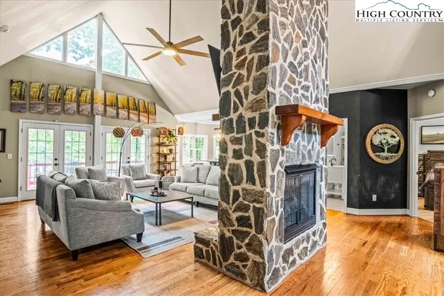 a living room with furniture a fireplace and a large window