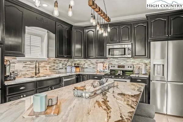 a kitchen with stainless steel appliances granite countertop a stove sink and cabinets