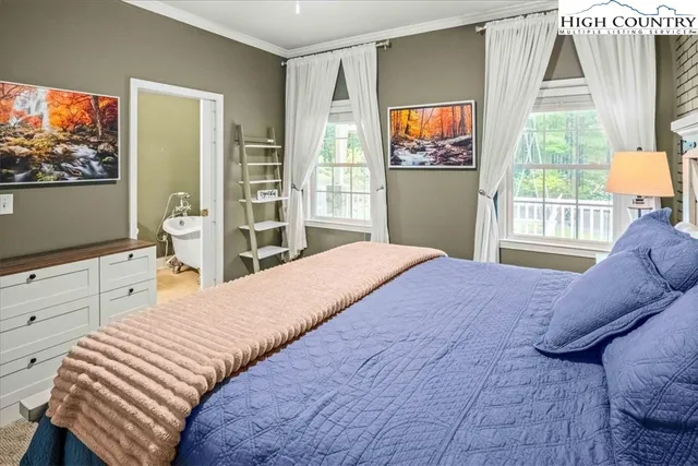 a living room with furniture a large window and a chandelier