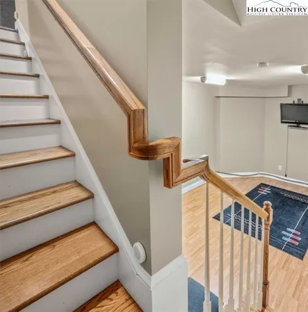 a view of an empty room with stairs and wooden floor