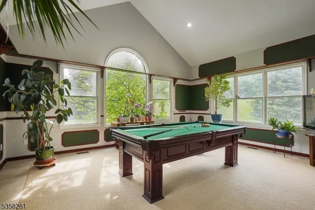 a room with pool table and windows