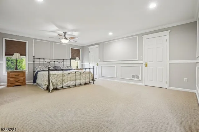 a spacious bedroom with a bed and ceiling fan