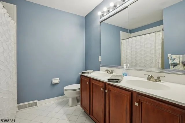a bathroom with a granite countertop sink a toilet and a mirror